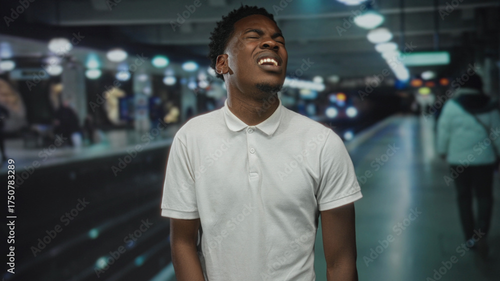Fototapeta premium Man grimaces on empty train station platform wearing white polo shirt; frustration delay commute hurry.