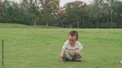 Asian babies playing with sticks on the grass in the morning, babies learning to walk