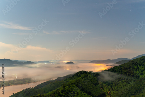 Wallpaper Mural A magical night view from Phu Pha Dak, Nong Khai, Thailand. A thick blanket of fog covers the valley, with the warm, glowing lights of a hidden city shining through the mist. Torontodigital.ca