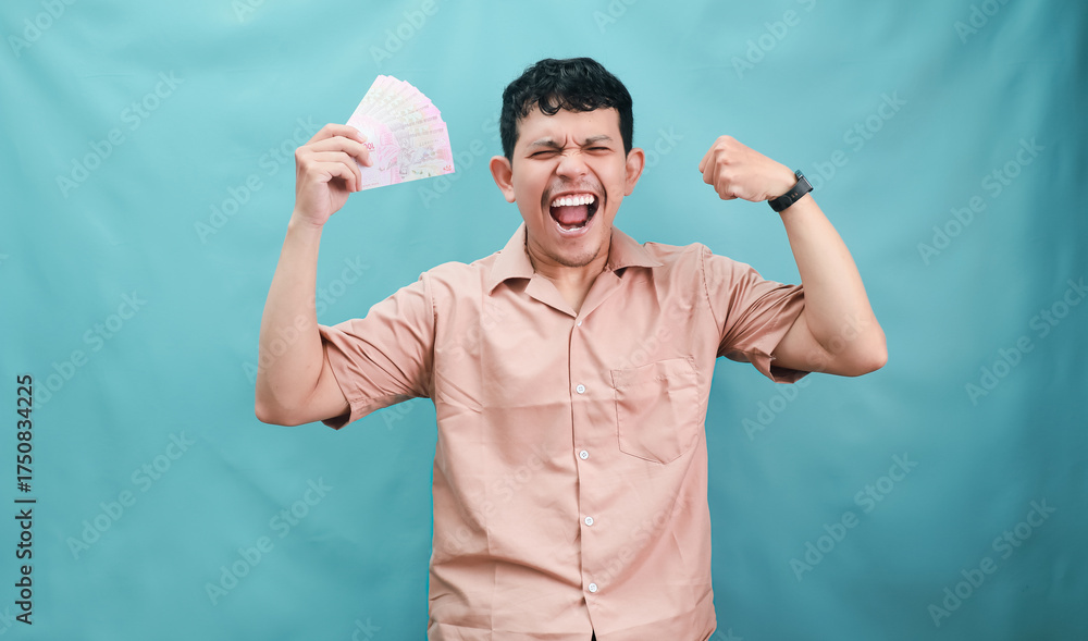 Fototapeta premium Excited Young Man Celebrating Success with Raised Fists and a Winning Ticket.