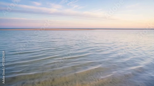 Calm Ocean Water At Sunset With Pastel Sky And Gentle Ripples Reflecting Soft Light
