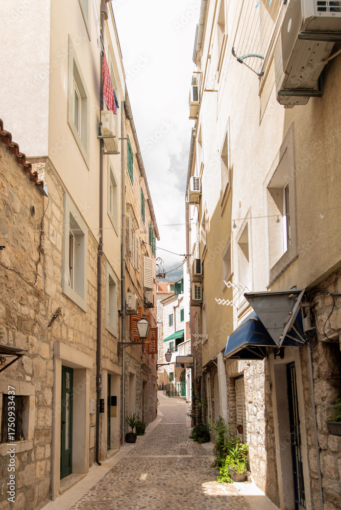 Fototapeta premium Narrow cobblestone alley with stone facades