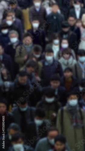 Wallpaper Mural Vertical shot with no focus of Asian people moving in sync through a packed walkway during Tokyo rush hour, showing impersonal urban life and societal pressure. Torontodigital.ca