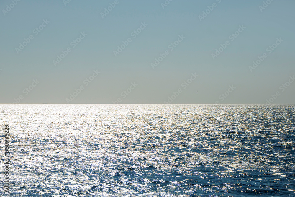 Fototapeta premium Sunset with shining waves and wide open sea view