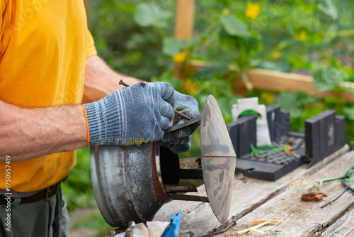 Papier peint A man wearing gray work gloves holds a chimney cap in his hands.
