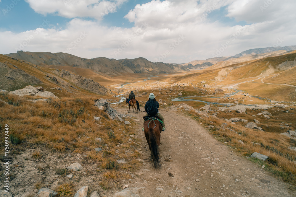 Fototapeta premium Tourists on horseback in Kurumduk valley Naryn province, Kyrgyzstan