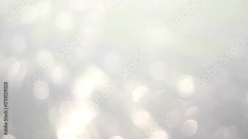 Glowing white bokeh flares motion background with soft sparkling blur effect