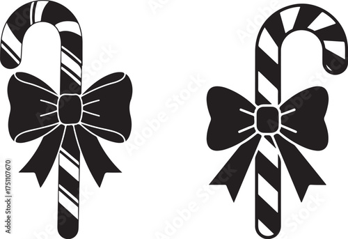Two black and white candy canes with festive ribbons and bows isolated on a white background