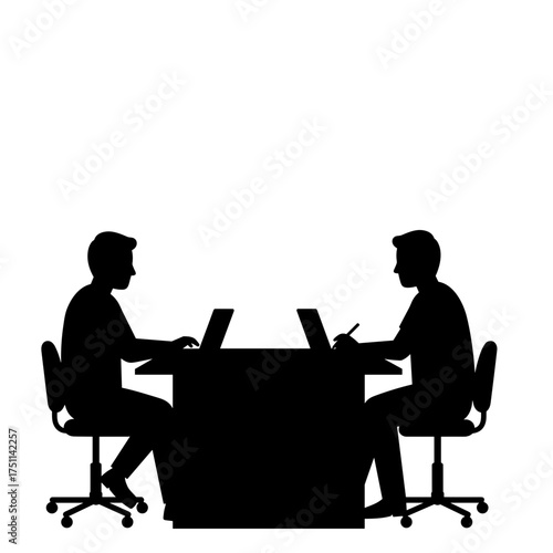 Two men collaborating on laptops while seated at a table