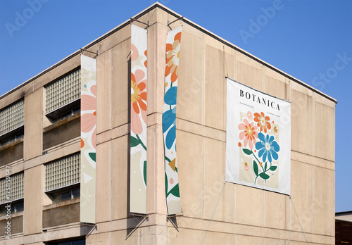 A mockup showing a blank canvas on a building wall with banners hanging.