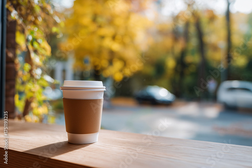 A cup of coffee to go from a coffee shop in autumn style. Fall morning. 