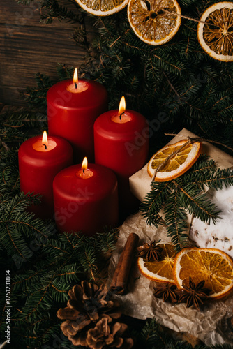 four burning Red advent candles in advent wreath decoration on wooden dark background. tradition in time before Christmas. xmas lights with christmas fir deco background concept. Festive still life.