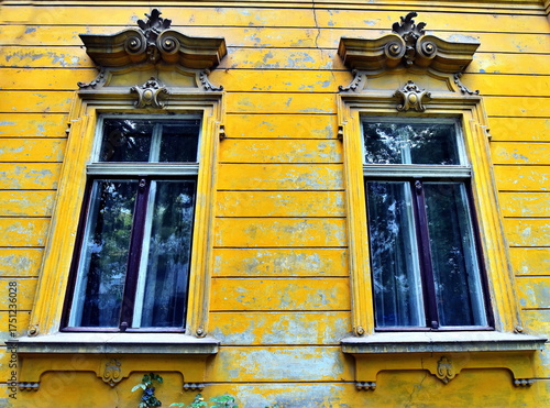 Old windows from 19 century with yellow facade.