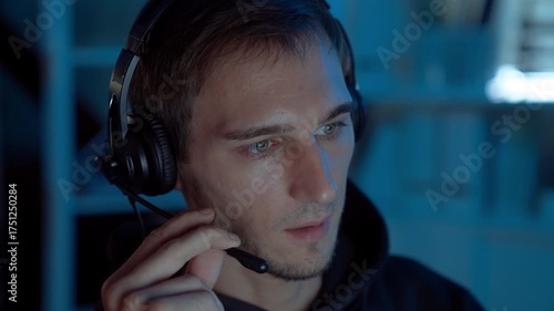 Professional IT support specialist wearing headset communicating with clients during night shift in call center office, showing reliability, remote assistance, and digital communication.