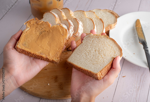 Manipulacion de alimentos, manejo de comida en la cocina, manos agarrando rebanadas de pan blanco para hacer sandwich de crema de cacahuate