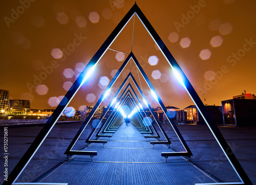 Glowing tunnel of triangular frames at night, with bokeh lights enhancing its surreal, dreamlike ambiance. Futuristic architecture symbolizing infinite possibilities and the journey into the unknown