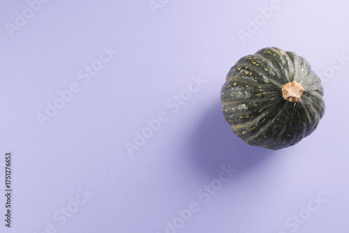 Green pumpkin on purple background