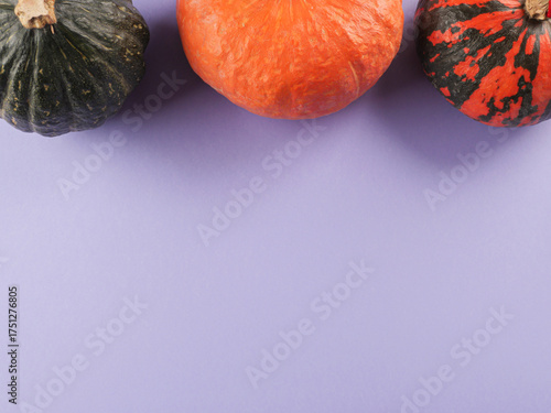 Three colorful pumpkins on purple background