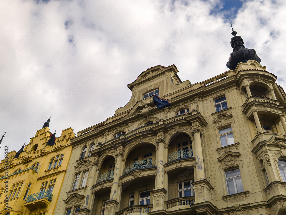 Obraz premium Wide angle shot of a row of magnificent classical buildings with diverse architectural styles and ornate details standing under a blue sky with white fluffy clouds.