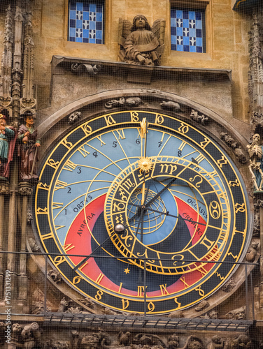 Macro shot of a stunning medieval astronomical clock with intricate golden dials and colorful segments representing time and celestial movements.
