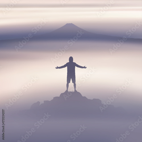 Solo climbing. Man with outstretched arms on top of rocky mountain in fog