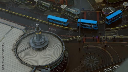 Drone footage of Liverpool city under light rain on an autumn day. Buses and cars move through wet roads, reflecting soft light. A melancholic yet peaceful mood, ideal for creative projects, branding 