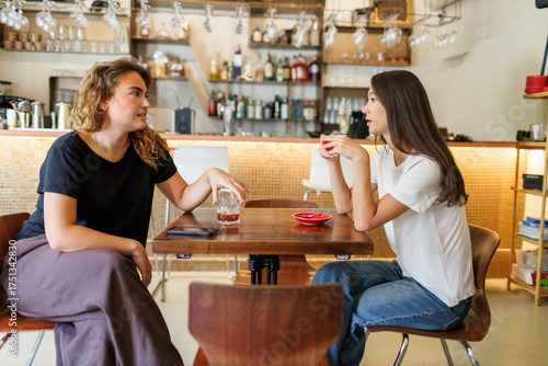 Two Girlfriends having a deep conversation at a cozy cafe in the afternoon