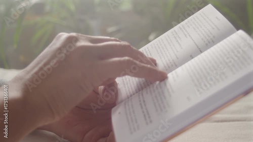 Close-up, female hands holding a book accompanying the lines read with a finger