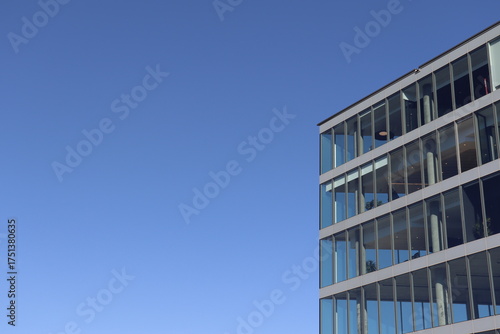 Modern office building with blue sky. Glass facade and modern architecture.