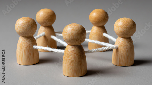 Connected Peg People: A symbolic representation of a collaborative network, with wooden peg people joined by interconnected cords, emphasizing the significance of teamwork and unity.