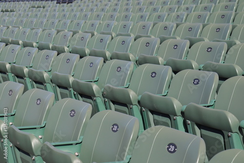 Rows of seats in stadium and outdoor event in summer. Outdoor architecture and exterior amphitheater with green seats. Seats design and public stadium. Outdoor show in summer.