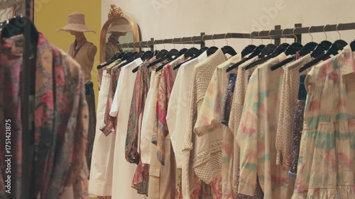 Cinematic close-up of elegant women’s clothing hanging on a rack and softly moving in warm light. Cozy, stylish boutique atmosphere perfect for fashion, advertising, and social media videos.