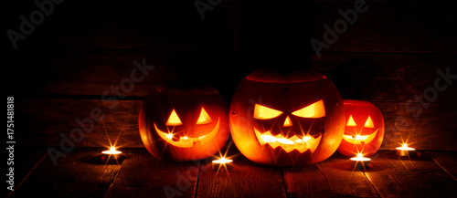 Halloween pumpkins with faces in a barn on a wooden background