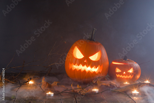 Halloween pumpkins with faces in a barn on a wooden background