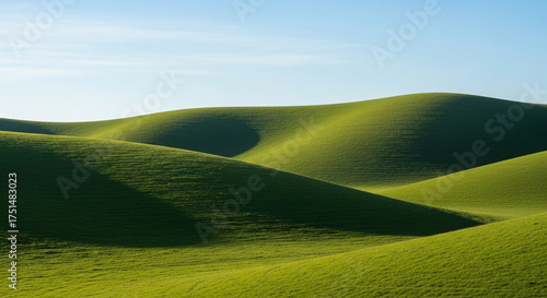 Rolling green hills under a clear blue sky create a peaceful and idyllic landscape, perfect for backgrounds, nature themes, or representing tranquility