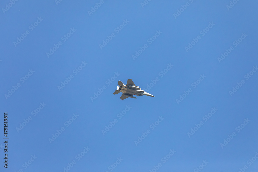 Obraz premium Close-up view of a modern twin engine fighter jet flying in clear blue sky, showing landing gear extended and aerodynamic shape of the aircraft used for aviation, defense, and aerospace purposes