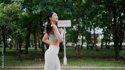 Close-up of an Asian woman jogging outdoors with a confident and focused expression, enjoying her morning run in the park