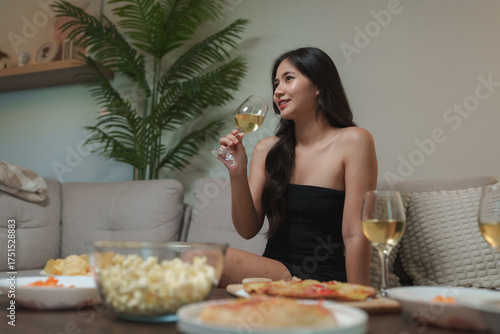 Fotografi Young woman enjoying wine at home evening