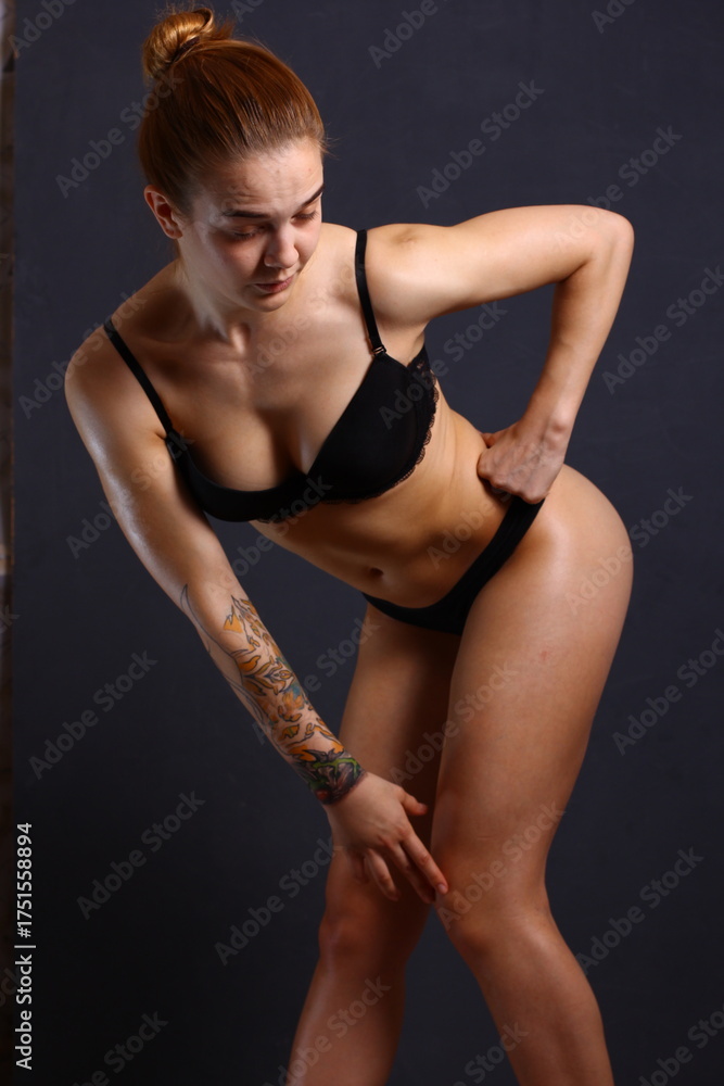 Obraz premium Beautiful young sexy cheerleader girl in black with tattoo on hand.