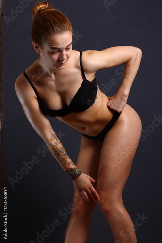 Beautiful young sexy cheerleader girl in black with tattoo on hand.