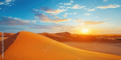 Fototapeta Naklejka Na Ścianę i Meble -  Desert landscape with sand dunes, a bright sun, and a blue sky with scattered clouds.