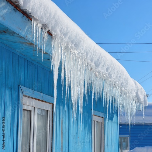 Icicles hanging from a blue roof in winter