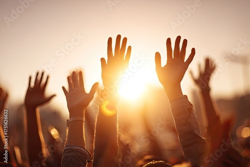 Hands raised in celebration at sunset
