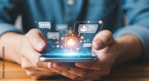 Hands holding smartphone displaying chat bubbles and user icons