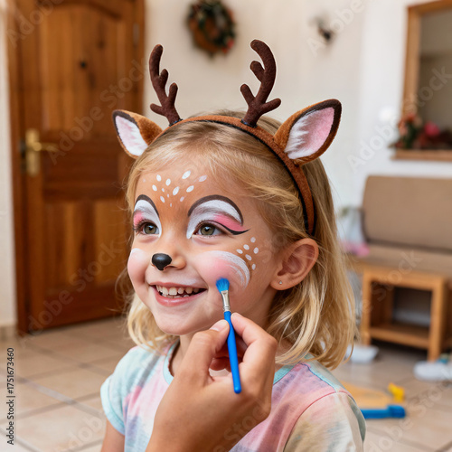 Joyful Girl With Deer Face Paint And Antler Headband Getting Makeup In Home Setting