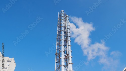 Wallpaper Mural Tall chimney of a mini-boiler room releasing white smoke against a blue sky. Industrial pipes, heat and electricity production, energy generation, and air emissions concept Torontodigital.ca
