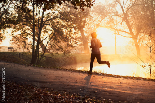 Φωτογραφία Active man jogging in park during autumn sunny morning