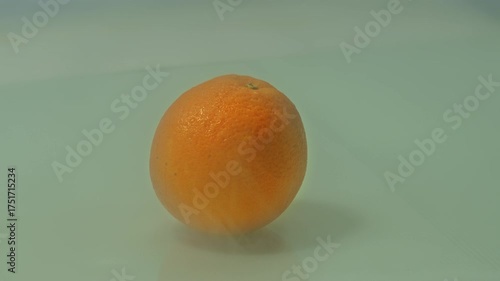 A fresh acid less orange surrounded by a thin mist, capturing the calm essence of morning freshness. The subtle moisture enhances its juicy texture and vibrant citrus tone.