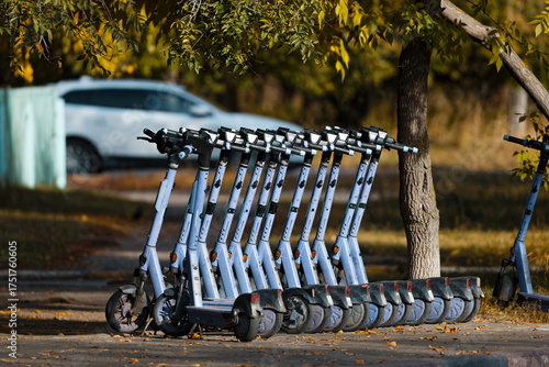 Row of Rental Escooters parked on a sidewalk on an Autumn City Street