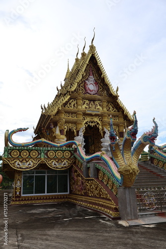 Wallpaper Mural An intricately designed wooden temple nestled amidst verdant trees. The temple's architecture is striking, with gold accents that glisten under the sunlight Torontodigital.ca